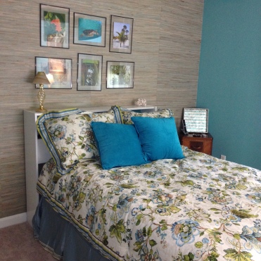 Photo of bed, bedding and grasscloth wallpaper
